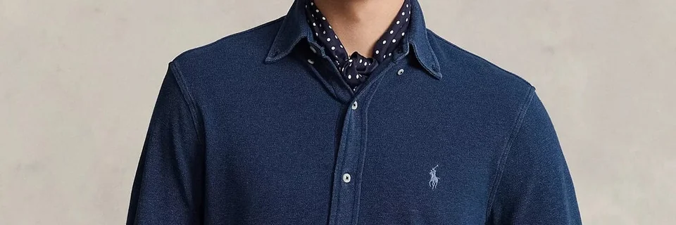Selected wide crop of the navy shirt showing its collar, buttons and embroidered chest logo